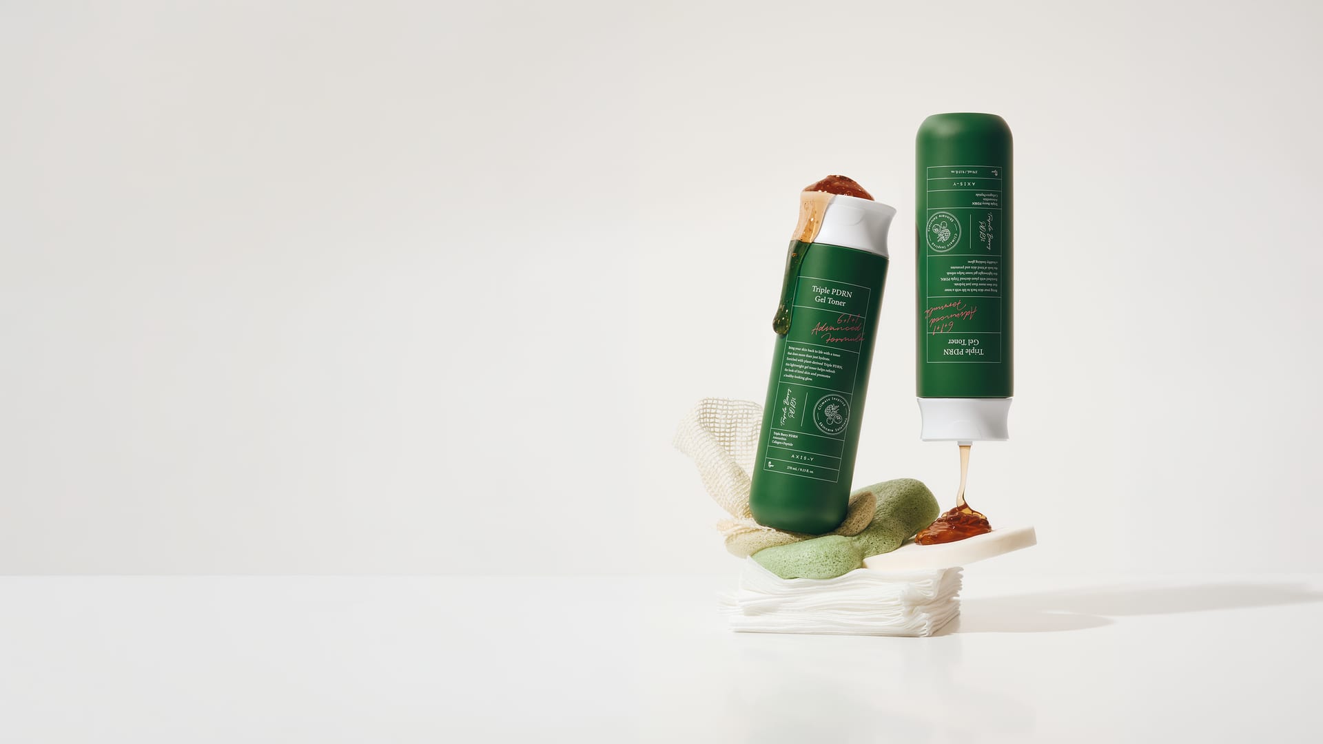 Zwei grüne Toner-Flaschen einer koreanischen Hautpflegemarke auf einem Stapel Wattepads